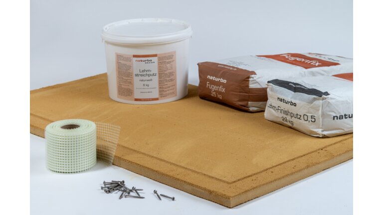 Bau- und Putzmaterialien auf Holzplatte.